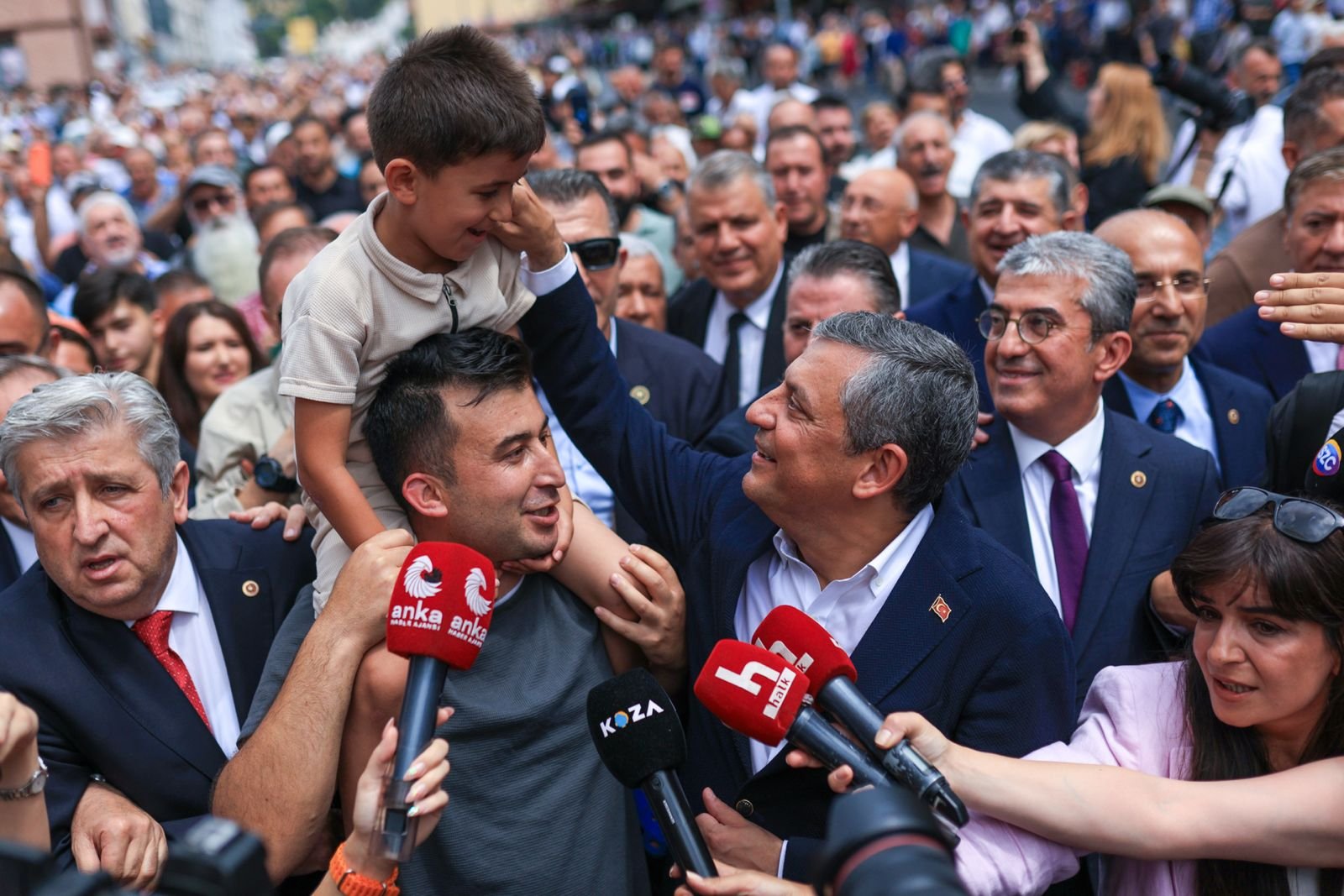Özgür Özel kalabalığın arasında bir çocukla sohbet ederken